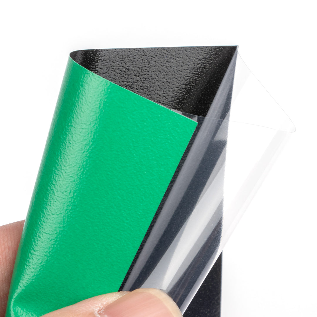 Green deck protector sleeve held by a hand.