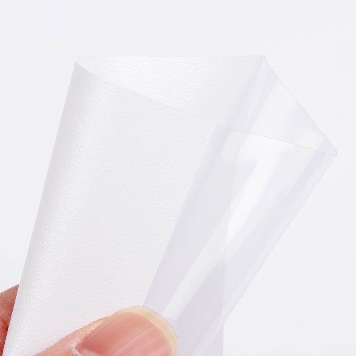 Close-up of a hand holding a white deck protector against a light gray background