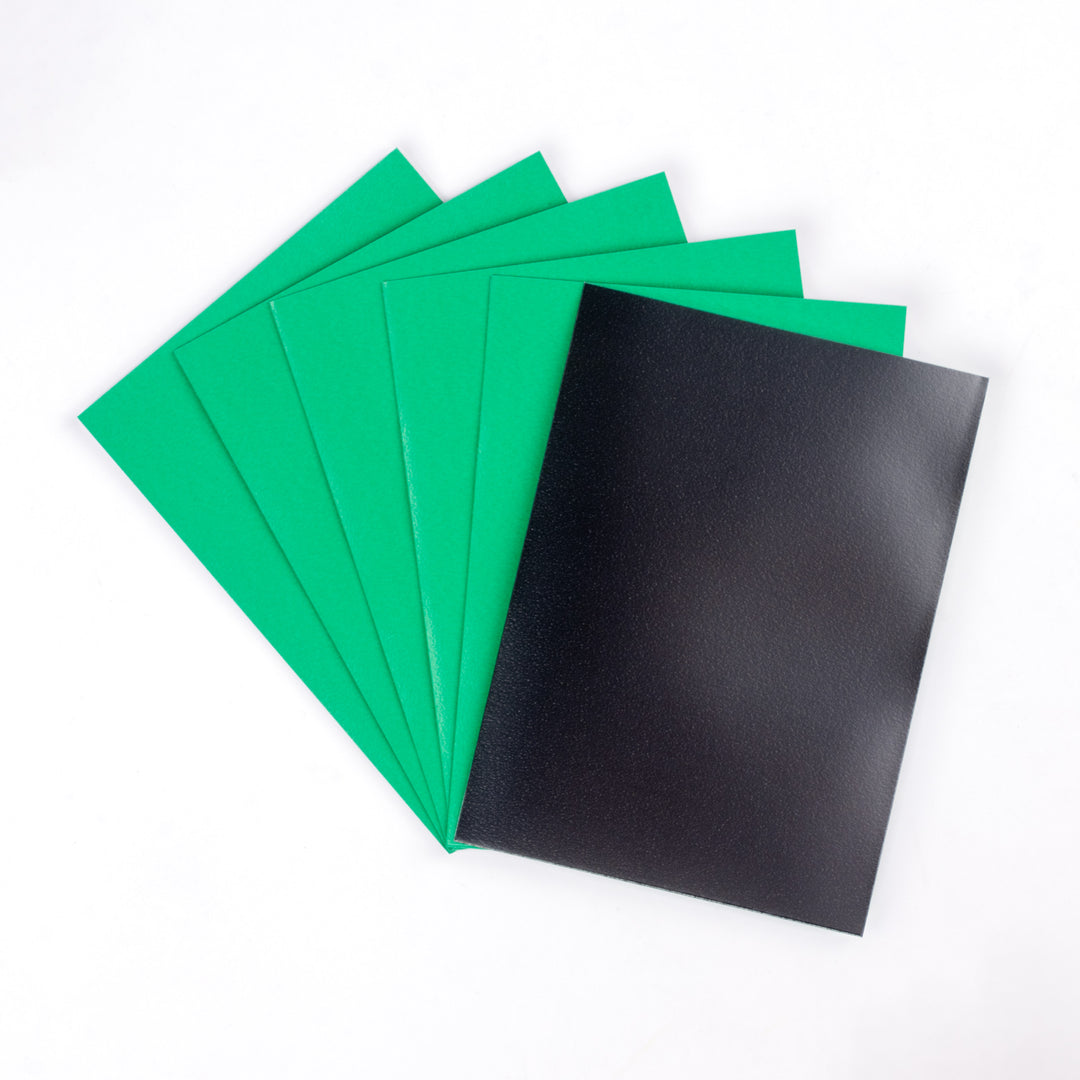 Five green matte deck protector sleeves and one black sleeve on a white background