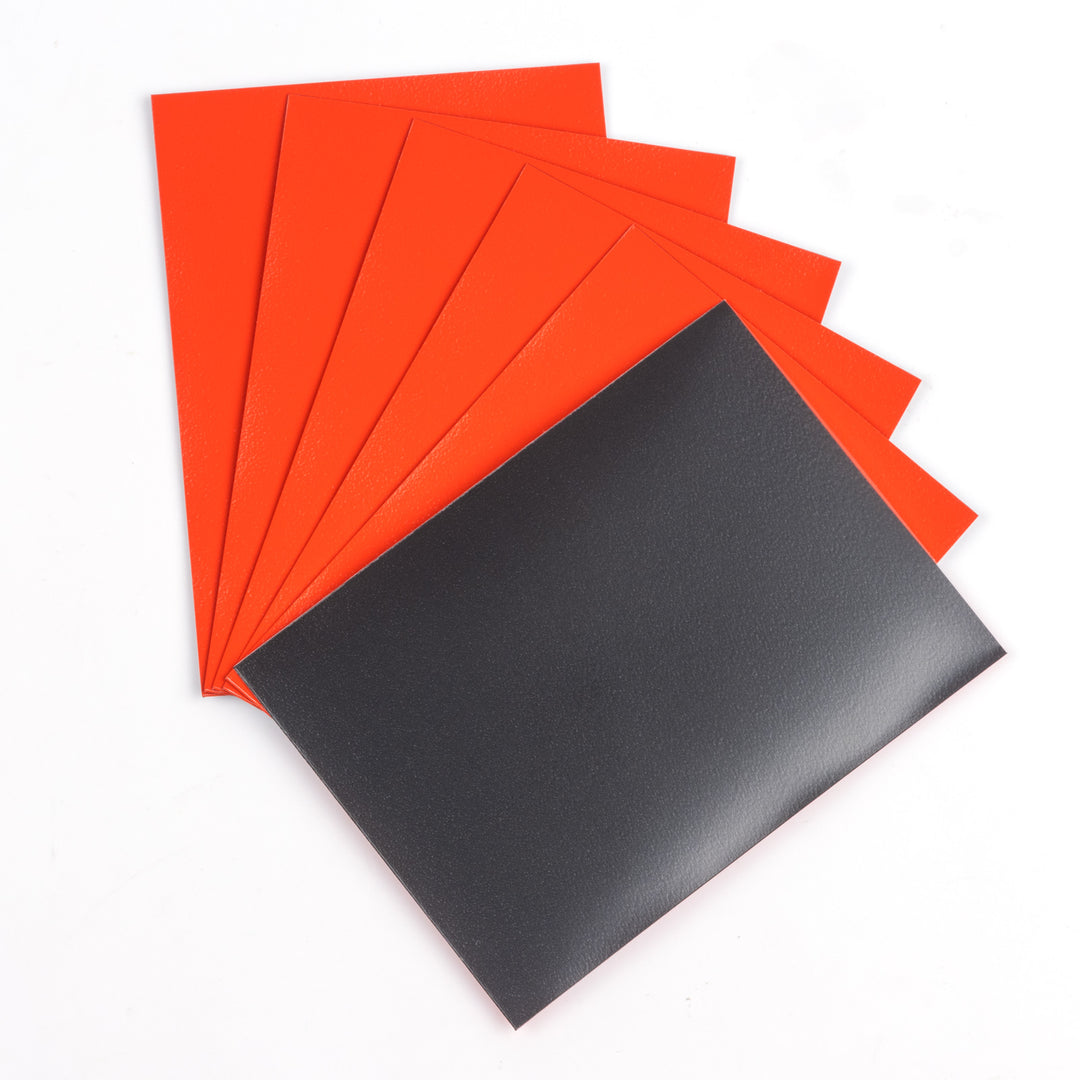 Black and orange matte deck protector sleeves on a white background