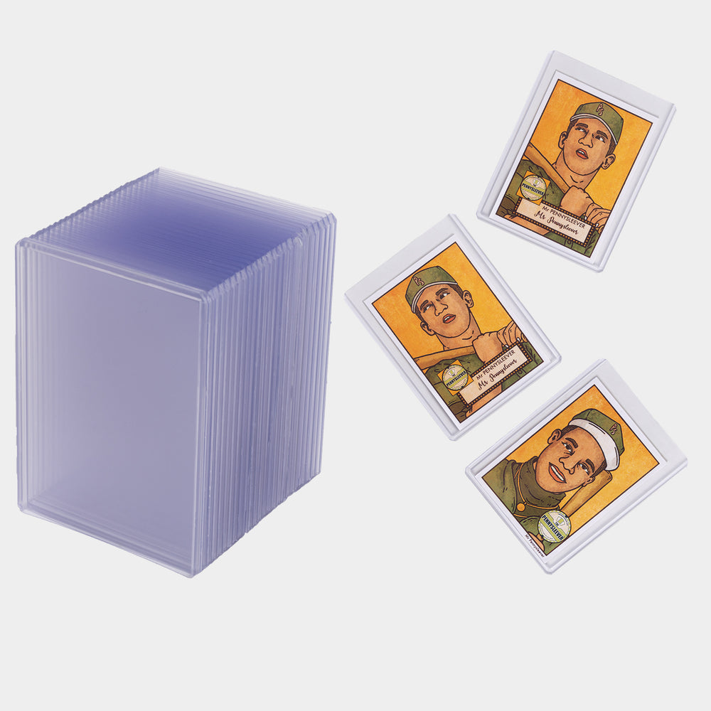 Three baseball cards in 100 point toploaders next to a large stack of toploaders.