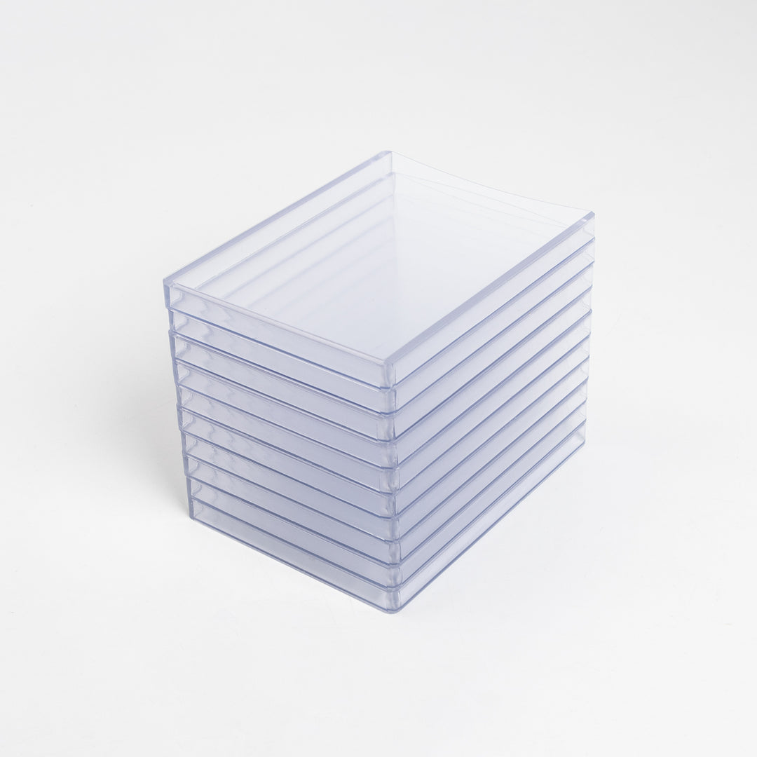 A high stack of 260 point toploaders on a white table.
