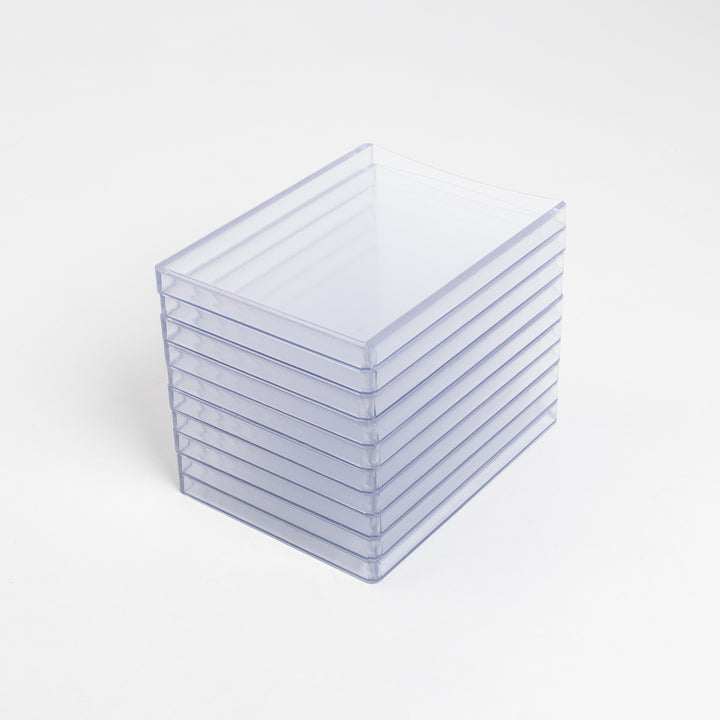 A high stack of 260 point toploaders on a white table.