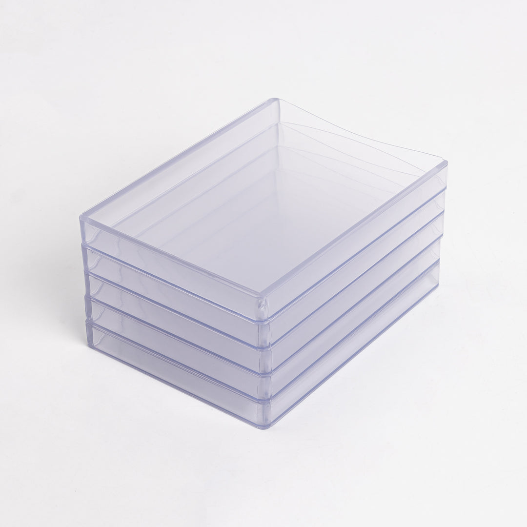 A stack of 360 point toploaders sitting on a white table.