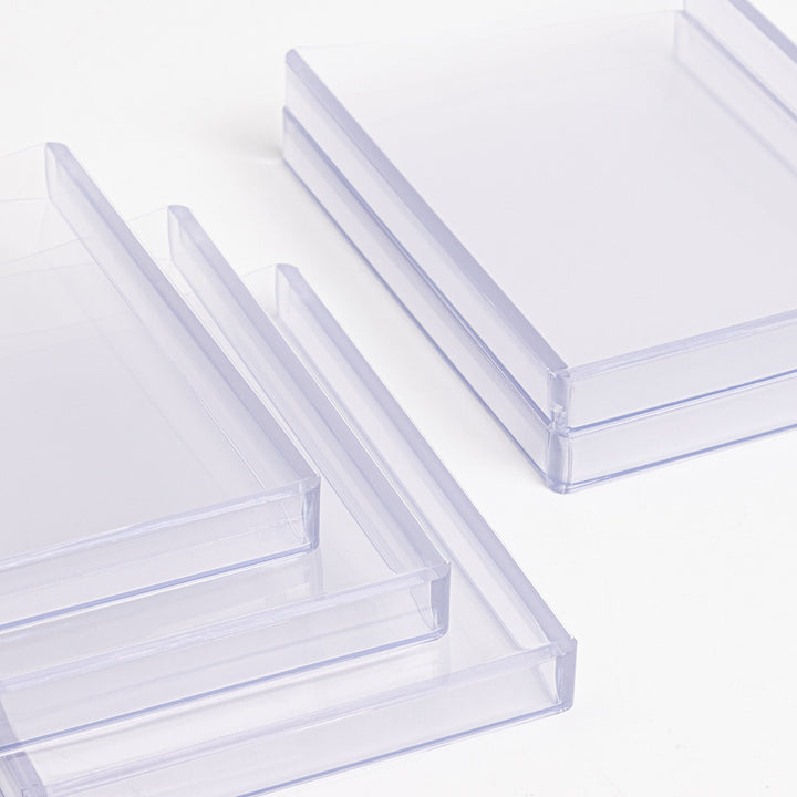A group of 360 point toploaders lying on a white table.