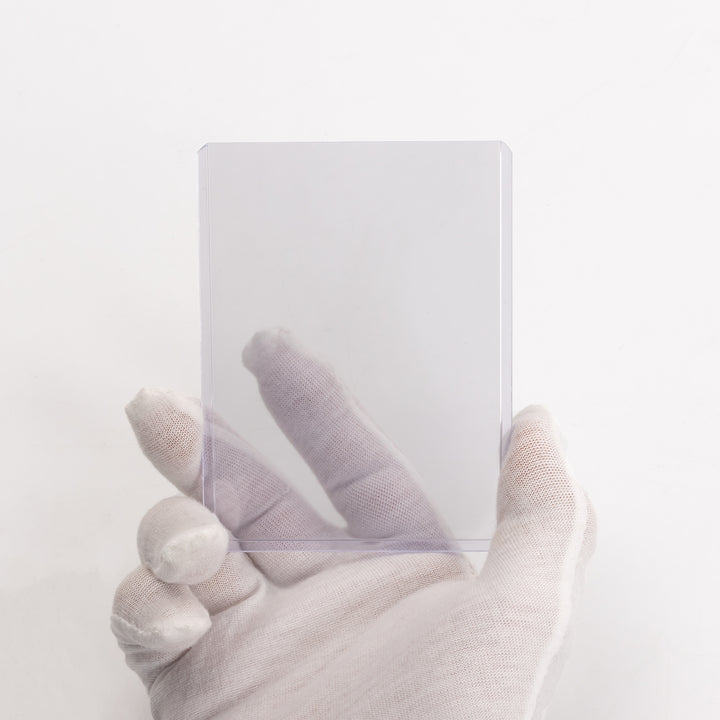 A white gloved hand holding a single 55 point toploader.